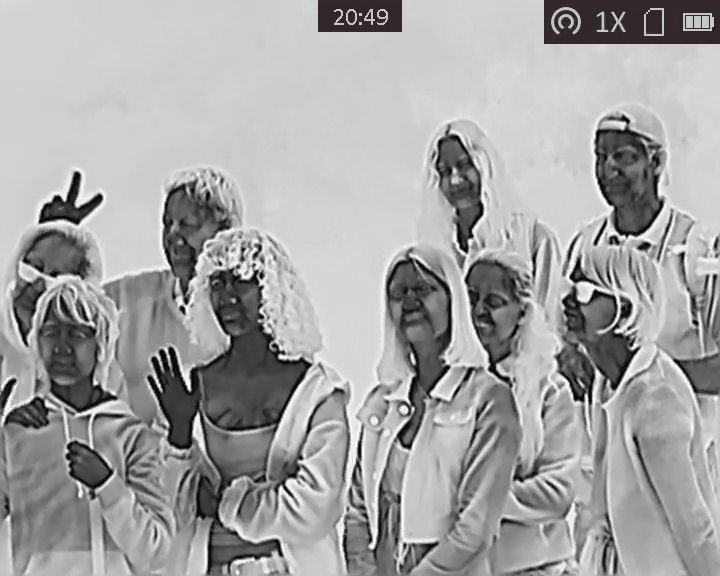 Photo taken on a thermal imaging camera, showing people looking for wildlife.