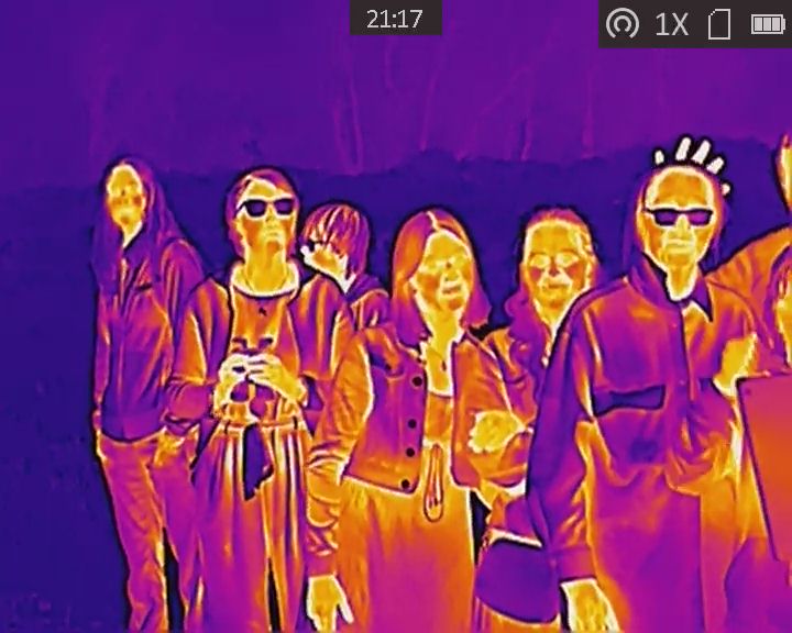 Photo taken on a thermal imaging camera, showing people looking for wildlife.