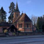 Photo of a brick built church with a tall spire.