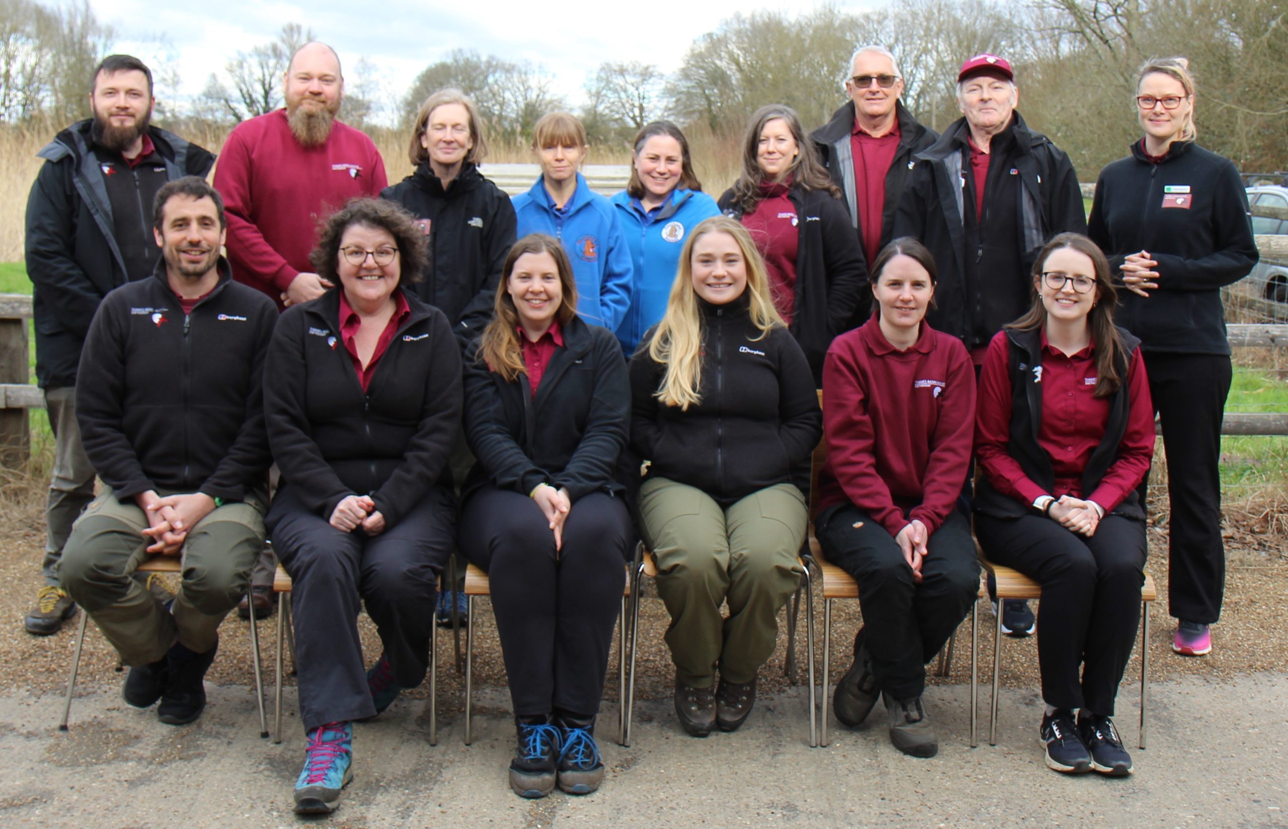 Photo of 15 team members in their Thames Basin Heaths uniforms - burgundy shirts and black jackets.