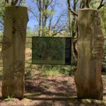 Photo of a noticeboard with information about the woodland. Two large Oak panels hold the sign.