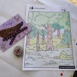 Photo of a selection of nature crafts - a bird greeting card, a decorated stone and a forest colouring sheet