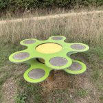 Photo of a children's play structure in the shape of a green flower