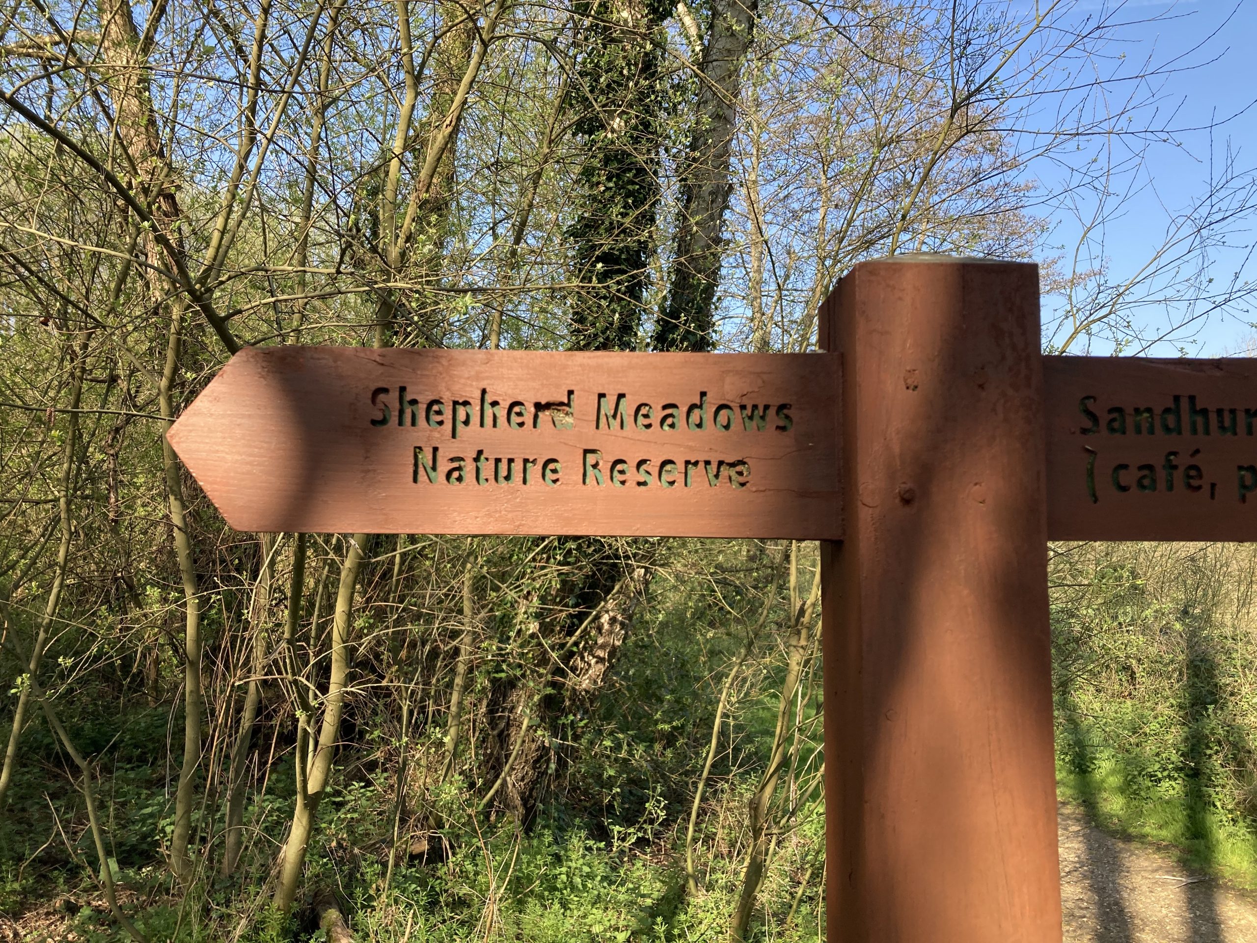 Photo of a wooden waymarker sign stating Shepherd Meadows Nature Reserve